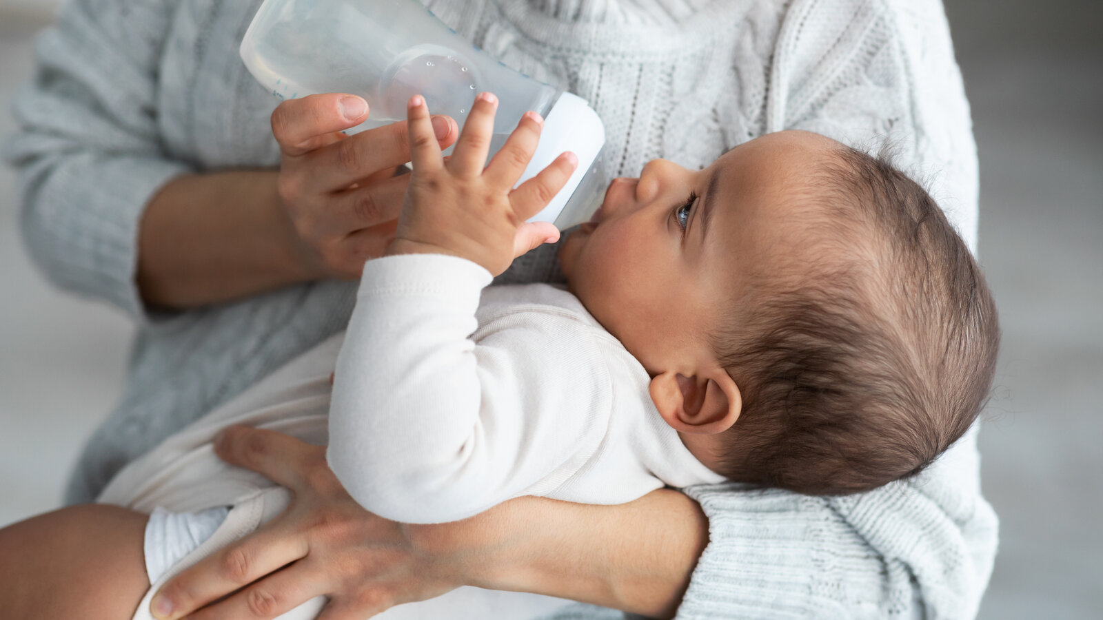 Bayi minum air dari botol — keamanan air demineral untuk susu formula